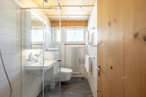 uma casa de banho com um lavatório e um WC em Chasa Val Parterre em Scuol