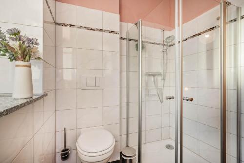 a bathroom with a toilet and a glass shower at Der Schlosshof - 02 in Pudagla