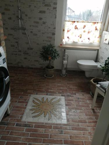 a bathroom with a toilet and a tile floor at Ferienwohnung Puttenusenhof in Klausdorf Brandenburg