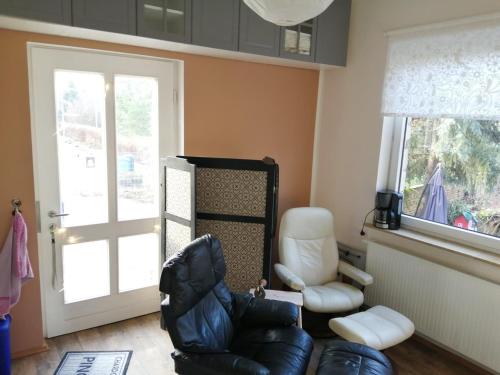 uma sala de estar com uma cadeira de couro e uma janela em Ferienwohnung Puttenusenhof em Klausdorf Brandenburg