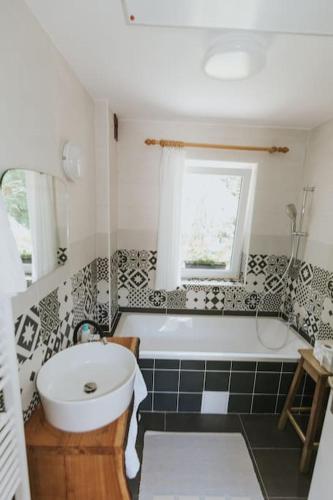 a bathroom with a white tub and a sink at Wine & Art Lodge Jeruzalem in Ljutomer