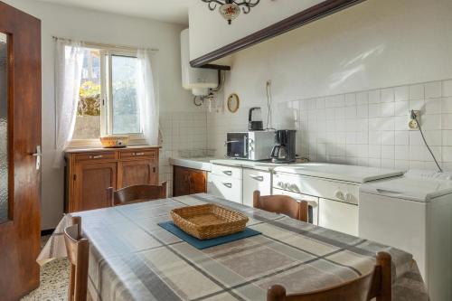 une cuisine avec une table et un panier dans l'établissement Entre Mer et Montagnes - Vue montagne, à Cervione