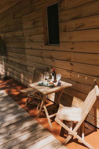 a wooden table with two chairs and a bottle of wine at Wine & Art Lodge Jeruzalem in Ljutomer