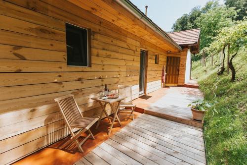 a wooden deck with chairs and a table on it at Wine & Art Lodge Jeruzalem in Ljutomer