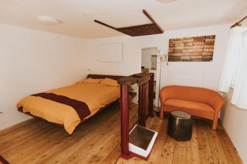a bedroom with a bed and a chair at Wine & Art Lodge Jeruzalem in Ljutomer
