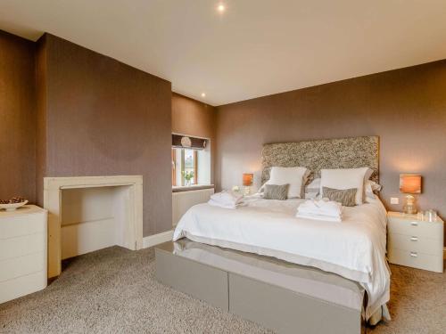 - une chambre avec un grand lit blanc et une cheminée dans l'établissement 3 Bed in Halifax 90209, à Sowerby Bridge