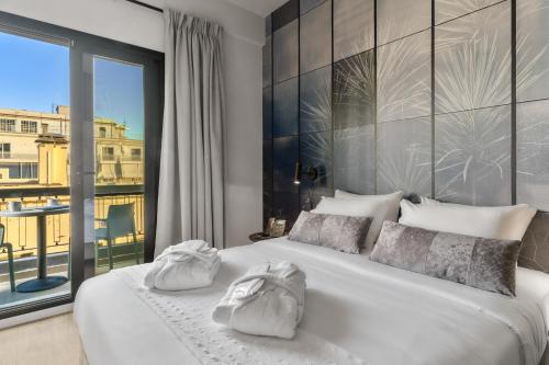 a bedroom with a white bed with a large window at Azur Hotel Volos in Volos