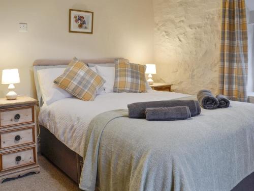 a bedroom with a bed with two pillows on it at Wren Cottage in Cwm