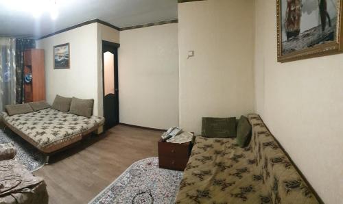 sala de estar con cama y sofá en 2- ух комнатная квартира, en Turksib