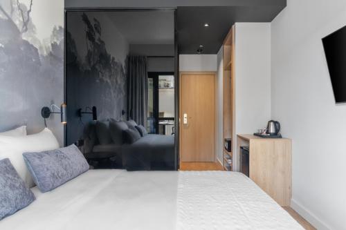 a bedroom with a large bed and a television at Azur Hotel Volos in Volos