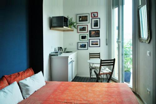 una camera con letto e una cucina con tavolo di Up to Seven a Milano