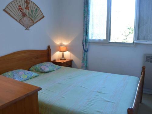 une chambre avec un lit, une lampe et une fenêtre dans l'établissement Appartement 2P à Fréjus, piscine, tennis, proche vieux Fréjus - FR-1-226A-18, à Fréjus