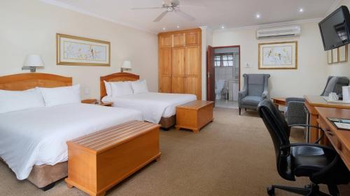 a hotel room with two beds and a desk at Protea Hotel by Marriott Polokwane Ranch Resort in Polokwane