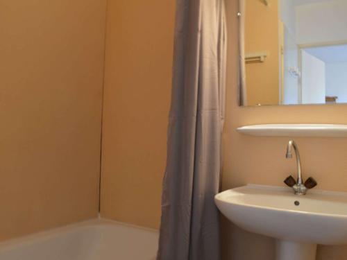 une salle de bain avec un lavabo et un rideau de douche dans l'établissement Appartement T2 avec Piscine, Proche Plage, Terrasse et Parking Privé à Saint-Cyprien - FR-1-225D-14, à Saint Cyprien Plage