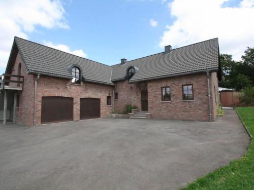 ein großes Backsteinhaus mit großer Auffahrt in der Unterkunft Cottage with swimming pool in Weismes