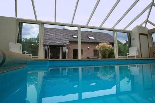 a swimming pool in front of a house at Cottage with swimming pool in Waimes