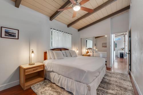 Un dormitorio con una gran cama blanca y una ventana en Walua Trail Estate, en Kailua-Kona