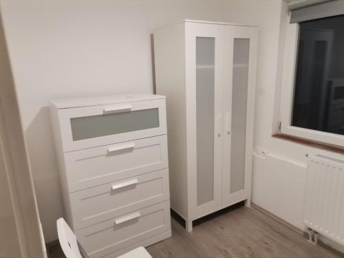 a white dresser in a room with a tv at Quiet Residential @ Agglomeration Taplanszentkereszt 2 Bedroom + Living room in Szombathely