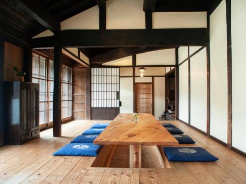 a large wooden table in a room with blue mats at RITA Izumo Sagiura in Izumo