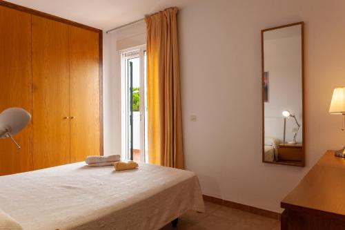 1 dormitorio con cama con espejo y ventana en Casa de Eva en Matalascañas, en Matalascañas