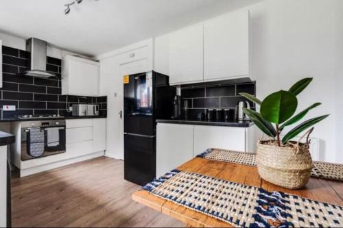 a kitchen with black and white appliances and a potted plant at New build house near Trafford Centre with drive in Manchester