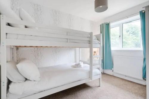 a white bunk bed in a room with a window at Newly renovated house near Trafford Centre in Manchester