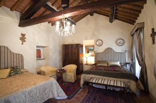 a bedroom with two beds and a chandelier at Dolce Maria in Cortona