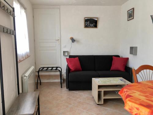 een woonkamer met een zwarte bank en een tafel bij Studio Lou Rigaou in Comps-sur-Artuby