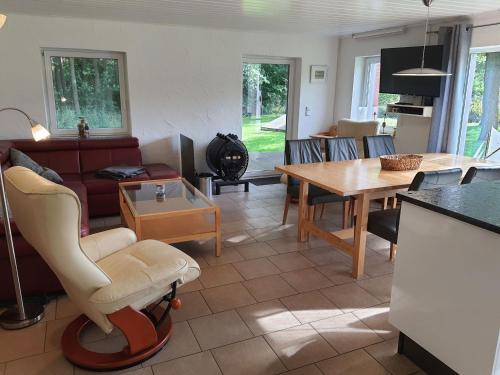 uma sala de estar com uma cadeira e uma mesa em Ferienhaus Erlengrund em Staphel