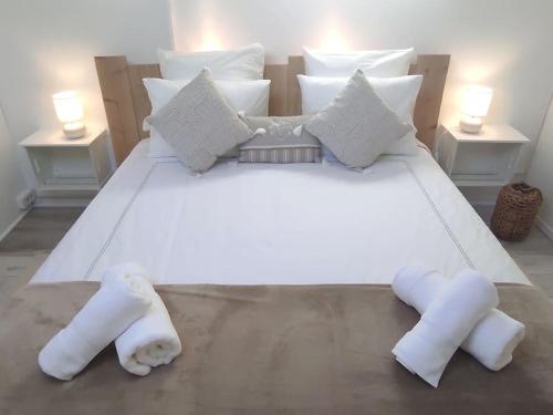 - un grand lit blanc avec deux animaux rembourrés dans l'établissement Maisonnette dans les Alpilles CLASSEE 3 ETOILES TOURISME, à Maussane-les-Alpilles