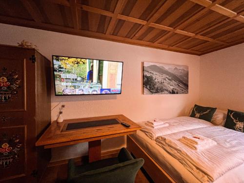 a small bedroom with a bed and a desk at Spitzen Blicke – Apartments in Silbertal
