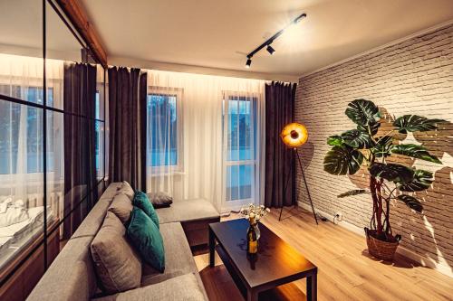 un soggiorno con divano e pianta di Elegance Loft Apartment a Skoczów