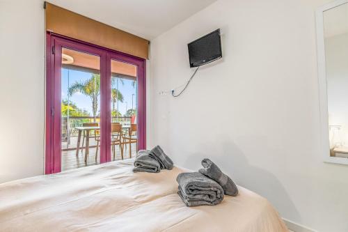 um quarto com uma cama, uma televisão e uma varanda em Apartamento Gran Terraza Vistas Mar em Pilar de la Horadada