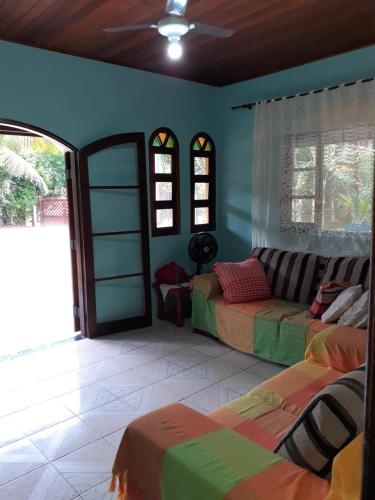 a living room with two beds and a couch at Casa Curral in Ilhabela