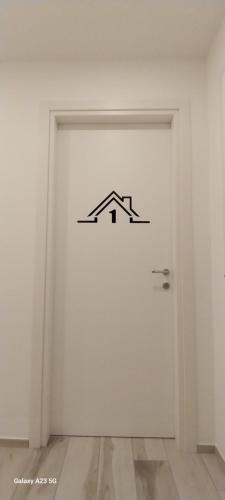 a white door with a house sign on it at Casa DelFalco in Domodossola