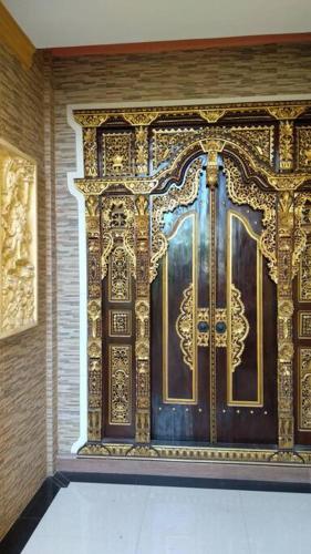 a golden door on the side of a building at Private Bali Artifac GuestHouse in Singaraja