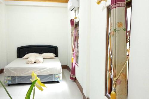 een kleine slaapkamer met een bed in een kamer bij Private Bali Artifac GuestHouse in Singaraja