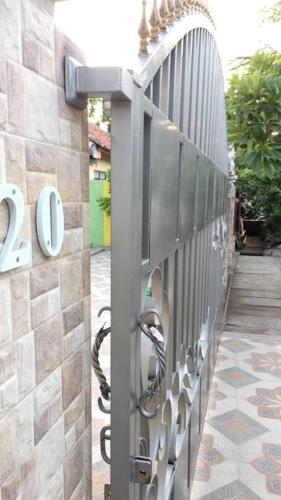 a metal fence with a sign on the side of a building at Private Bali Artifac GuestHouse in Singaraja