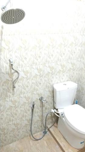 a bathroom with a toilet and a shower in it at Private Bali Artifac GuestHouse in Singaraja