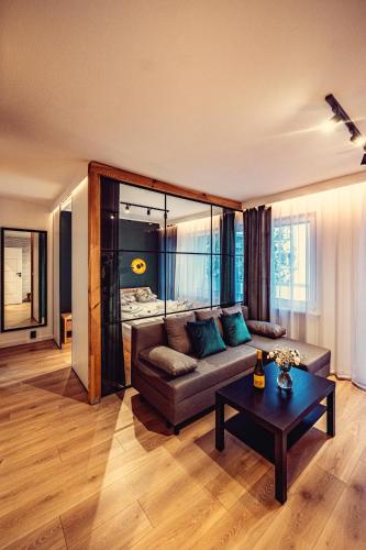 a living room with a couch and a table at Elegance Loft Apartment in Skoczów