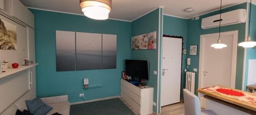 a living room with blue walls and a television at L'alloggetto sul Corso in Cuneo