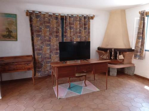 a living room with a desk with a television on it at Le Castel des Seigneurs in Antananarivo
