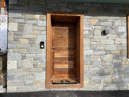 a stone building with a wooden door on it at Chalet L'Alpaga in Châtel