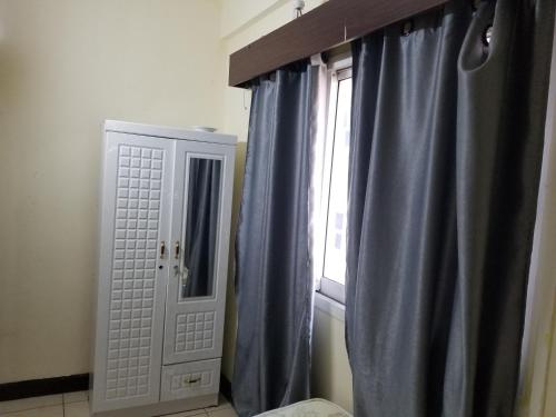 a bathroom with a window with blue curtains at Partition Rooms in Hotel Apartment in Dubai