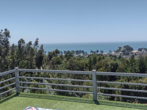 a white fence with the ocean in the background at Pingueral Casa 07 in Dichato