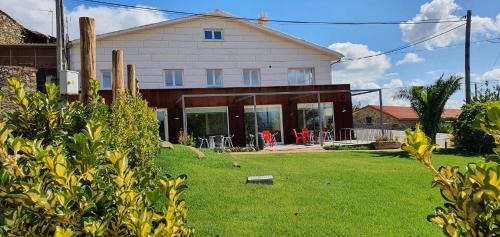 une maison avec une pelouse devant elle dans l'établissement Hotel Gastronómico Gandainas, à Riós