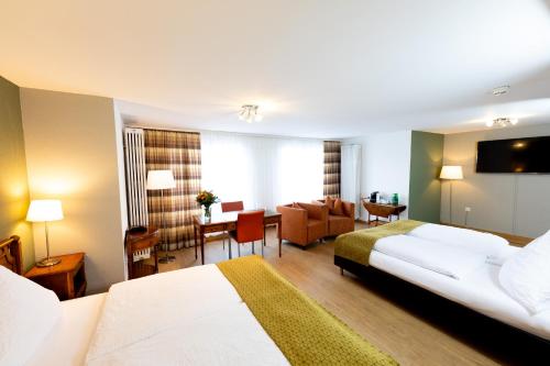 a hotel room with two beds and a living room at Hotel Alfa in Basel