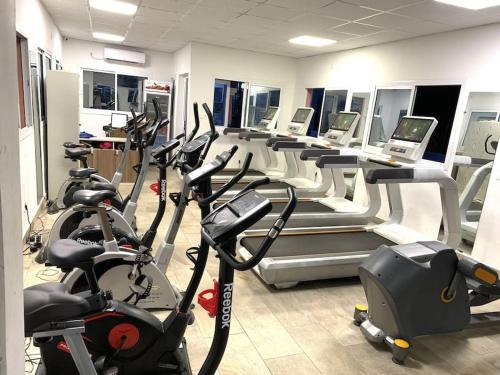 a gym with rows of treadmills and exercise bikes at Appartement famille 03 chambres in Douala