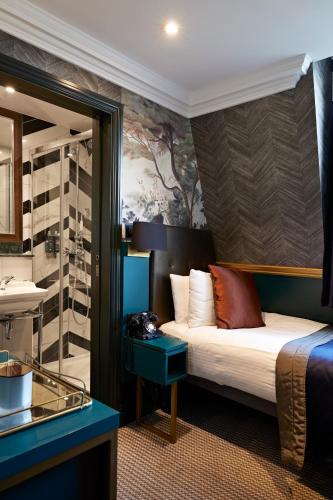 a hotel room with a bed and a mirror at The Portico Hotel in London