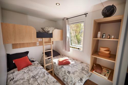 Habitación pequeña con 2 camas y ventana en TAIGA Almeria Playa, en Palomares